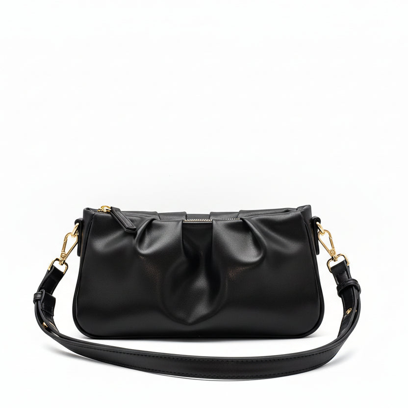 Black handbag with a strap on a gray background